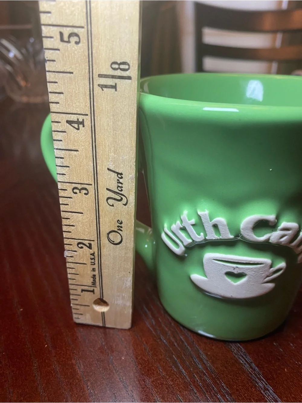 Urth Cafe ceramic coffee mug in green with white embossed logo